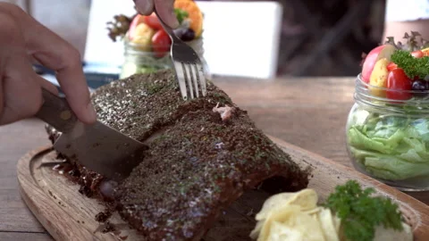 Hands cutting bbq pork ribs cover in sauce and spices rustic yummy American s Stock Footage 201000662