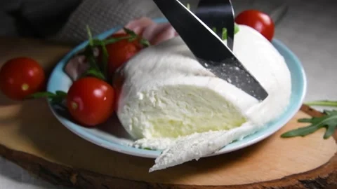 The hands cutting a big mozzarella cheese, food made in Puglia Stock Footage 131557087