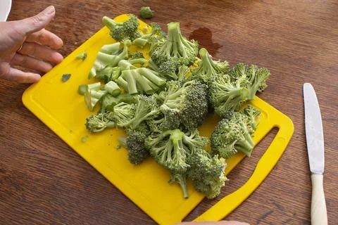 Hands cutting broccoli cabbage. Healthy green vegetables. Stock Photos