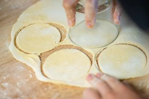 Hands cutting circles from raw dough sheet stock photo Stock Photos
