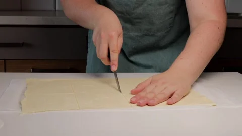 Hands cutting dough evenly on table surface, dough preparation showing prec.. Stock Footage 320955940