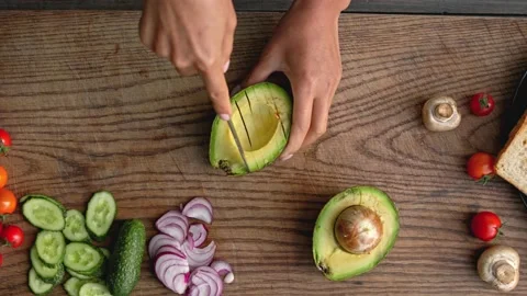 Hands cutting fresh avocado and vegetables on the wood board Stock Footage 160850482