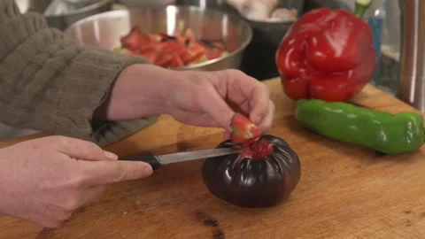 Hands cutting a fresh heirloom tomato on a wooden board Stock Footage 331218557