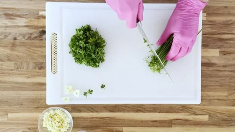 Hands cutting fresh herbs such as parsley and chives Vídeos de archivo 335165904