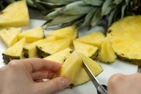 Hands cutting fresh pineapple fruit into pieces. 스톡 사진