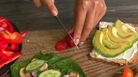 Hands cutting fresh red tomato for avocado toast Video stock 160850574