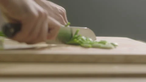 Hands cutting green onion in half Video stock 198937377