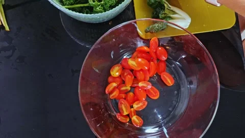 Hands cutting greens and dropping into bowl, kitchen, culinary prep Video stock 334526787