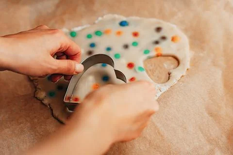 Hands Cutting Heart Shape Cookie From Dough With Colorful Pieces Stock Photos