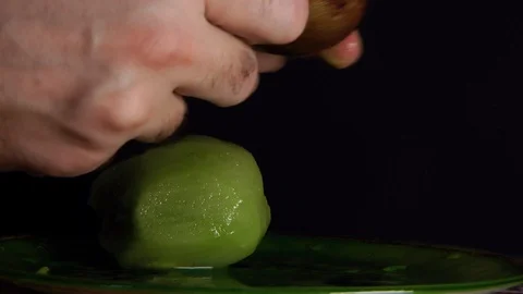 Hands Cutting Kiwi on black background Stock Footage 85992073