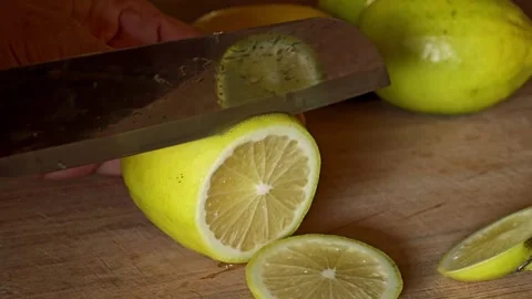 Hands cutting lemons on cutting board. Stock Footage 309023060