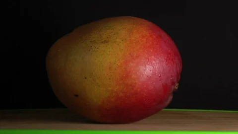 Hands Cutting Mango on black background, slow. Stock Footage 84910621