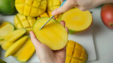 Hands Cutting Mango Half into Cubes with Knife, Close-Up Stock Footage 327118427