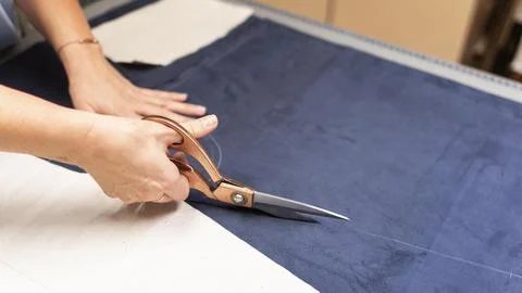 Hands cutting material with scissors close up Stock Photos