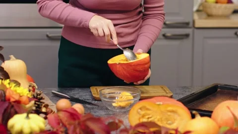 Hands cutting orange ripe raw pumpkin peel remove pumpkin seeds with spoon for Stock Footage 219967795