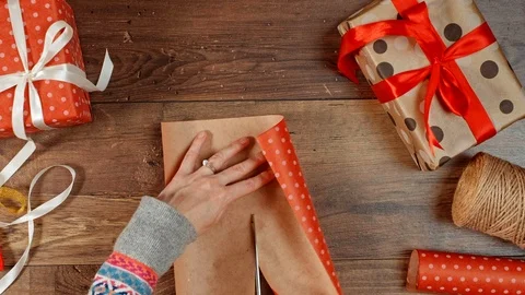 Hands cutting paper, wrapping present for holidays. Packaging wrapped gift box. Stock Footage 117189578