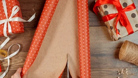 Hands cutting paper, wrapping present for holidays. Packaging wrapped gift box. Video stock 117189603