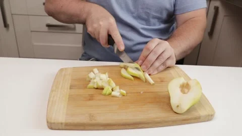 Hands cutting a pear close-up, man preparing fresh ingredient, healthy eati.. Stock Footage 303216351