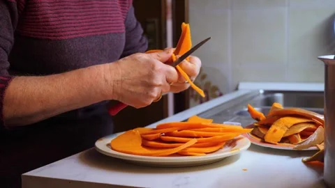 Hands cutting pumpkin into thin slices for Italian gratin Stock Footage 305268323