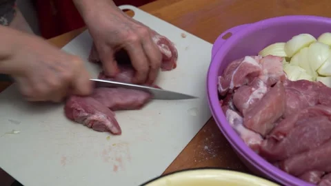 Hands Cutting Raw Meat On Cutting Board In Kitchen With Bowl Of Meat Preparation Stock Footage 325101158