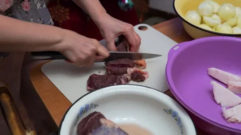 Hands Cutting Raw Meat On Cutting Board In Kitchen With Bowl Of Meat Preparation Stock Footage 329213600