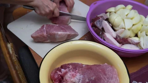 Hands Cutting Raw Meat On Cutting Board In Kitchen With Bowl Of Meat Preparation Видео 336482331