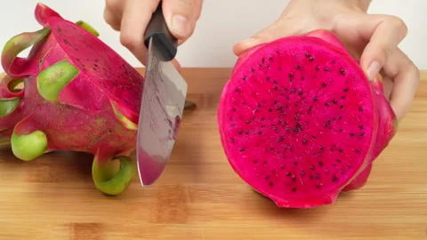 Hands Cutting Ripe Dragon Fruit (Pitaya) in Half on Wooden Cutting Board 4K Stock Footage 320619189