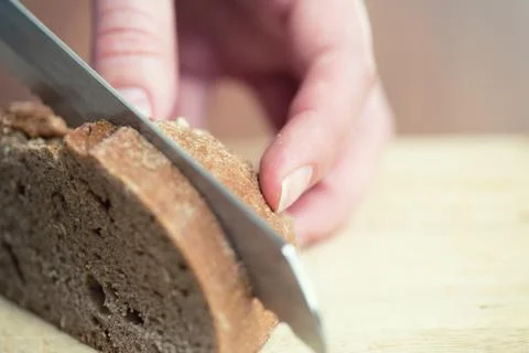 Hands cutting rye bread 写真素材