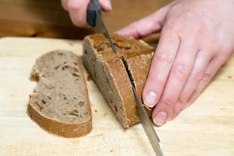 Hands cutting rye bread 写真素材