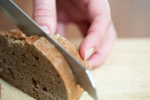 Hands cutting rye bread Stock Photos