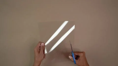 Hands Cutting Transparent Cardstock With Scissors for DIY Craft Project Indoors Vídeos de archivo 345617032