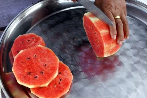 Hands cutting a watermelon Stock Photos