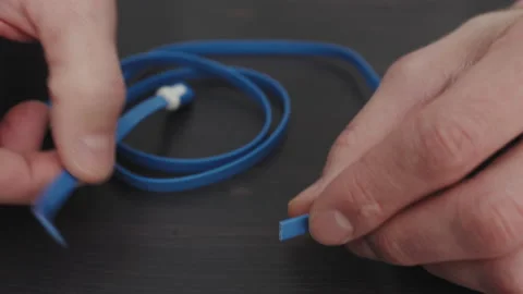 Hands cutting wire on wooden table in close-up Stock Footage 235911603