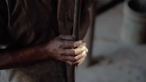 The hands of a dark skinned worker holding a metal pole for manual labor. Stock Footage 144660784