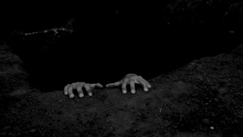 The hands of a dead man protrude from the pit. Black and white scary video 스톡 동영상 286035123