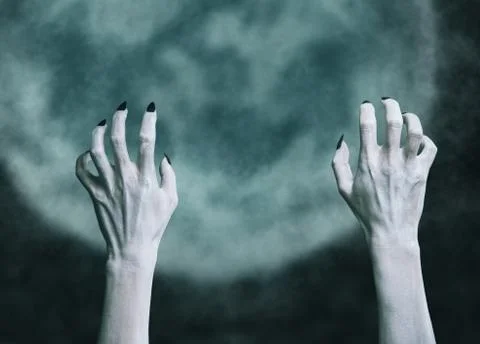 Hands of a dead zombie man on background of full moon. Stock Photos