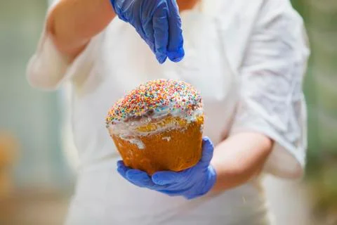 Hands decorate Easter bun. Professional baking Easter cakes. Stock Photos