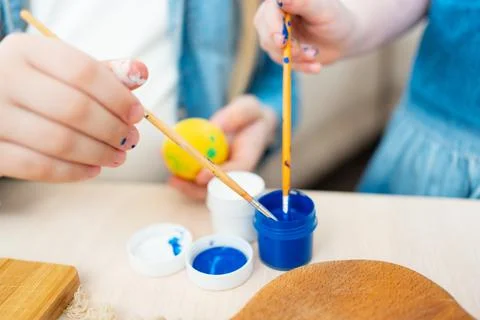 Hands decorate Easter eggs with paints. Easter tradition Stock Photos