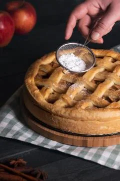 Hands decorating apple pie with powdered sugar. Homemade dessert. Baked pastr Stock Photos