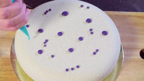 Hands decorating the cake with silver droplets Stockbeeldmateriaal 98101401