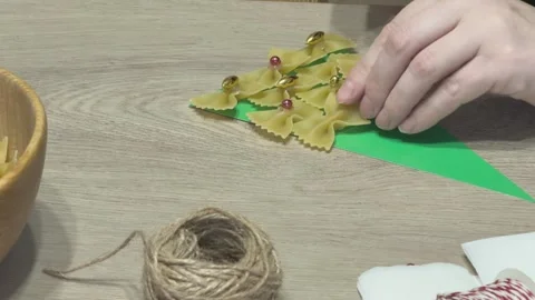 Hands Decorating Pasta Christmas Tree With Beads On Paper Festive Diy Craft For Stock Footage 341985718