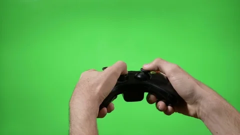 Hands of dedicated young gamer using a game controller with green screen in b Video stock 83112767