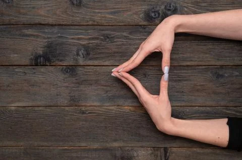 Hands delicately arranged in an triangle shape, showcasing fine details of .. Stock Photos