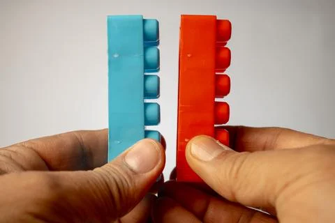 Hands demonstrating the interlocking mechanism of two common plastic toy bu.. Foto stock