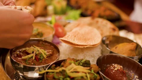 Hands Dipping Naan Bread into Traditional Indian Thali Platter Video stock 337690953