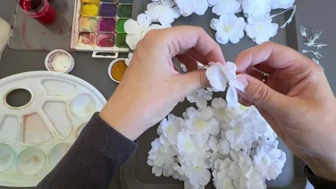 Hands disassembling white artificial flower parts before hand painting Stock Footage 345718674