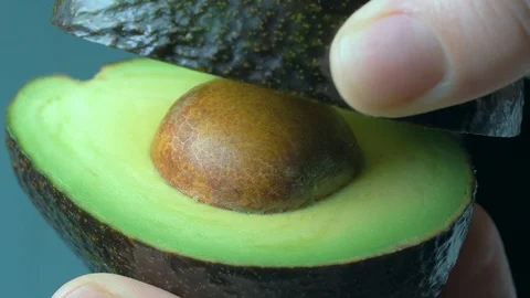 Hands dissolve fruit of avocado. Slow motion Stock Footage 105345872