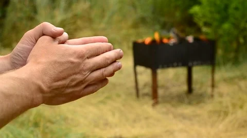 Hands of disturbed man with fire in brazier on background Stock Footage 56101506