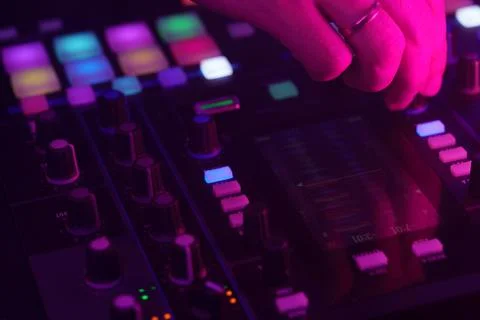 Hands of a DJ creating and regulating music on dj console mixer at club concert Stock Photos