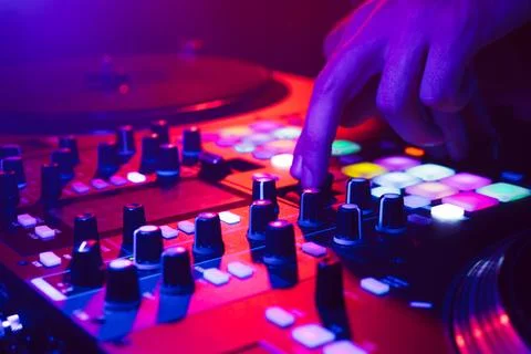 Hands of a DJ creating and regulating music on dj console mixer at club concert Stock Photos